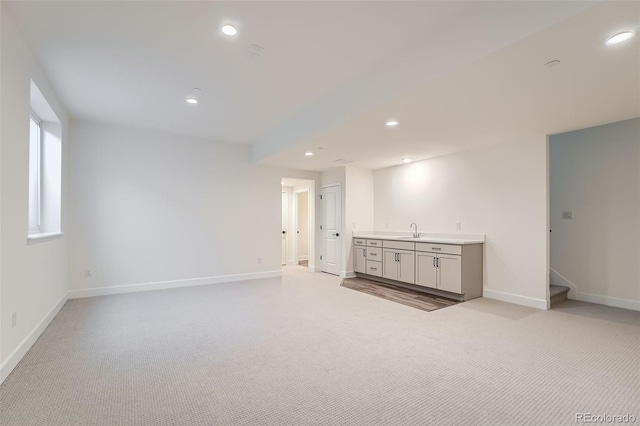 spare room featuring sink and light colored carpet