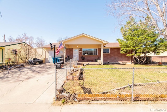 ranch-style home with concrete driveway, a front yard, brick siding, and a fenced front yard