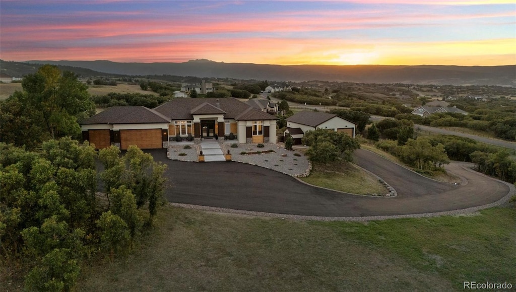 aerial view at dusk featuring a mountain view