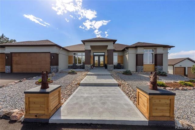 prairie-style home featuring a garage and french doors