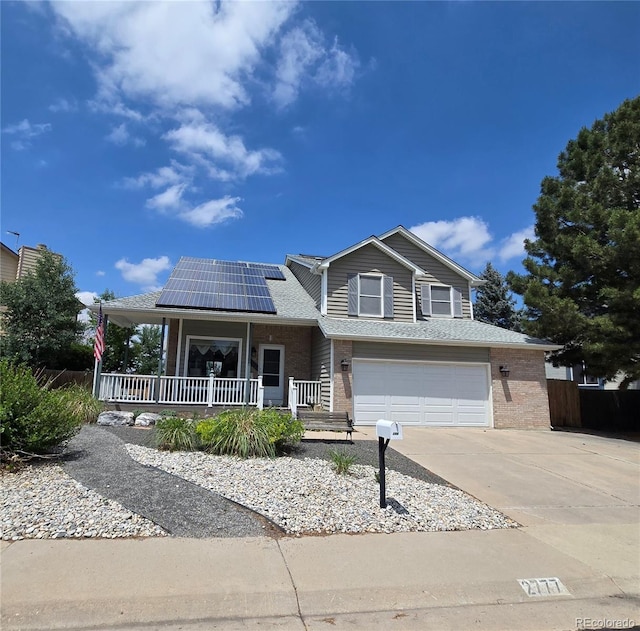 2777 W 106th Cir, Denver, CO 80234 - view of front of property with a porch, concrete driveway, brick siding, a garage, and roof mounted solar panels