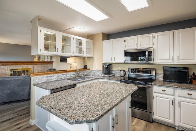 2777 W 106th Cir, Westminster, CO 80234 - kitchen with stainless steel appliances, light stone counters, white cabinetry, and light wood-style flooring