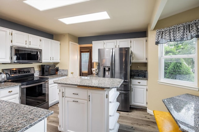 2777 W 106th Cir, Westminster, CO 80234 - kitchen with appliances with stainless steel finishes, light wood-type flooring, light stone countertops, and white cabinets