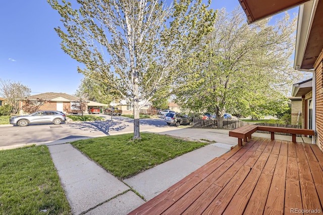 wooden terrace with a residential view and a yard