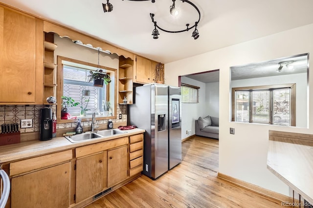 kitchen with stainless steel fridge with ice dispenser, a sink, open shelves, light countertops, and decorative backsplash