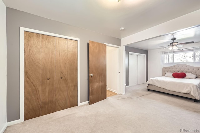bedroom featuring multiple closets, carpet floors, baseboards, and ceiling fan
