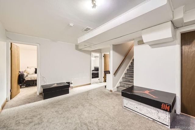 finished below grade area with carpet flooring, stairway, and baseboards