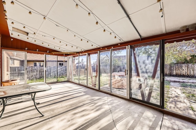 unfurnished sunroom featuring vaulted ceiling