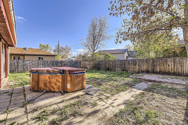 fenced backyard featuring a hot tub