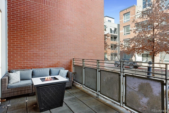 balcony featuring an outdoor living space with a fire pit