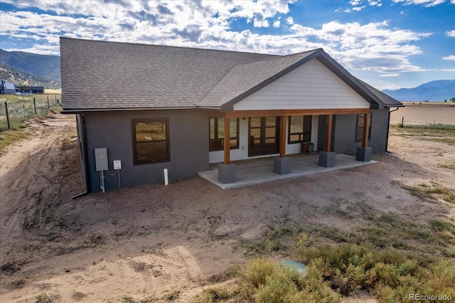 back of property featuring a mountain view and a patio area