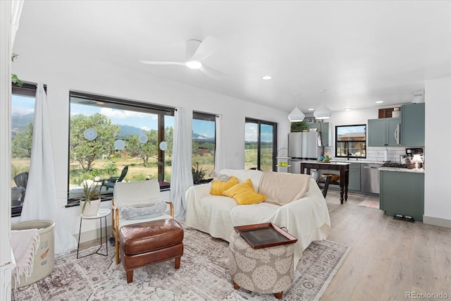 bedroom with ceiling fan, stainless steel fridge, and light hardwood / wood-style floors