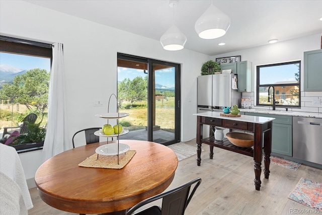 dining room featuring a wealth of natural light, sink, and light wood-type flooring