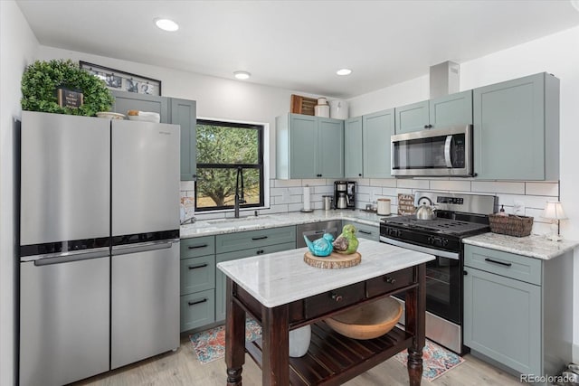 kitchen featuring light stone countertops, appliances with stainless steel finishes, and backsplash