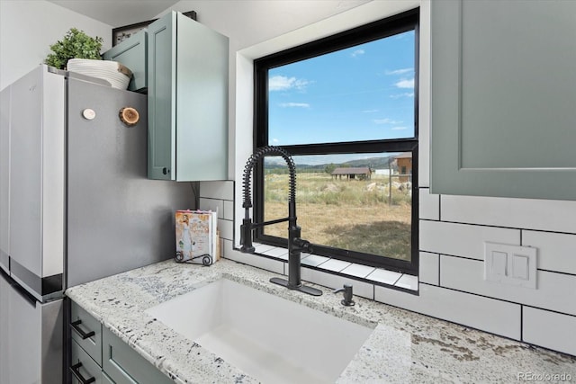 kitchen featuring light stone countertops and sink