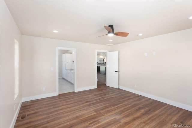 unfurnished bedroom featuring connected bathroom, ceiling fan, and dark wood-type flooring