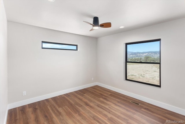 unfurnished room featuring ceiling fan and dark hardwood / wood-style floors