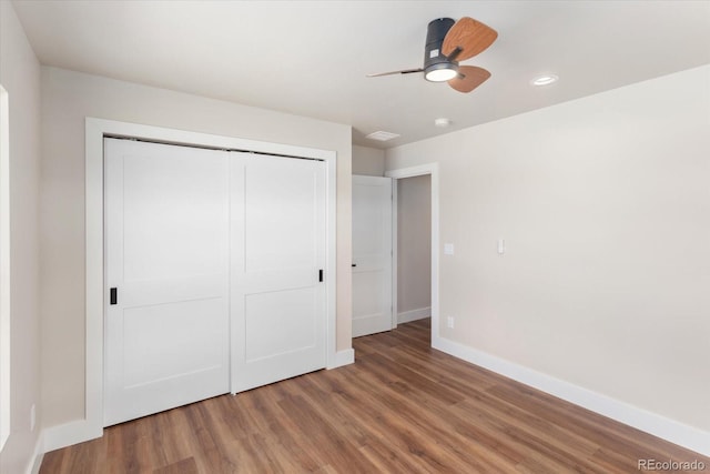 unfurnished bedroom featuring ceiling fan, a closet, and wood-type flooring