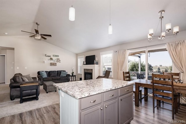 kitchen with decorative light fixtures, wood-type flooring, gray cabinets, and lofted ceiling