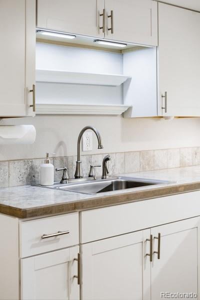 kitchen featuring white cabinetry and sink