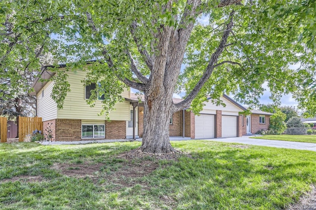 11310 W 46th Ave, Wheat Ridge, CO 80033 - tri-level home with brick siding, an attached garage, and driveway