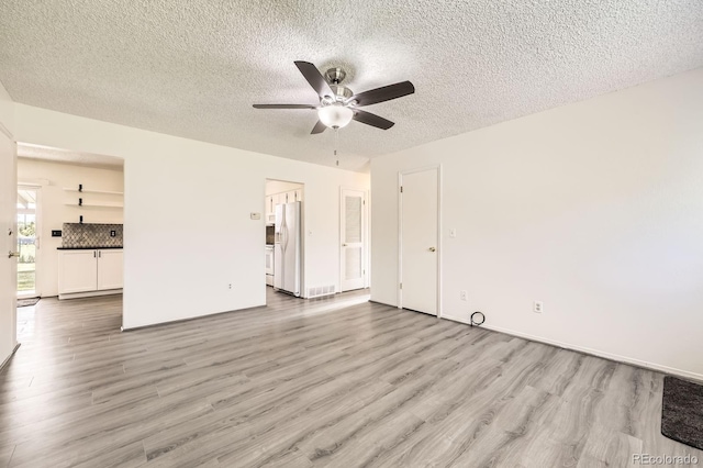 11310 W 46th Ave, Wheat Ridge, CO 80033 - unfurnished living room featuring ceiling fan, wood finished floors, a textured ceiling, and baseboards