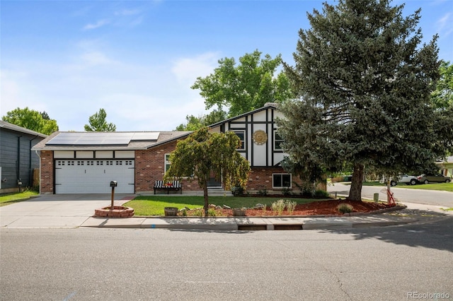 4501 S Garrison St, Littleton, CO 80123 - view of front of house featuring concrete driveway, brick siding, solar panels, a garage, and a front lawn