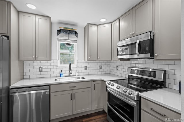 4501 S Garrison St, Littleton, CO 80123 - kitchen with appliances with stainless steel finishes, gray cabinetry, light countertops, decorative backsplash, and recessed lighting