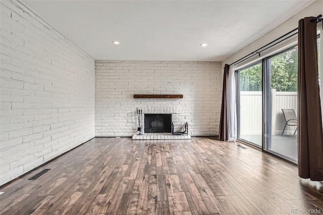9605 E Kansas Cir Unit 53, Denver, CO 80247 - unfurnished living room featuring a brick fireplace, wood finished floors, brick wall, and recessed lighting