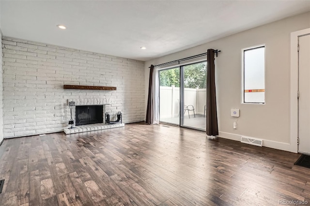 9605 E Kansas Cir Unit 53, Denver, CO 80247 - unfurnished living room with a brick fireplace, wood finished floors, baseboards, and recessed lighting