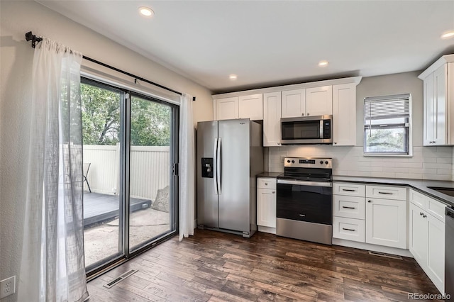 9605 E Kansas Cir Unit 53, Denver, CO 80247 - kitchen featuring stainless steel appliances, dark countertops, healthy amount of natural light, dark wood-style flooring, and recessed lighting