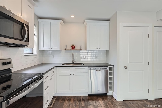 9605 E Kansas Cir Unit 53, Denver, CO 80247 - kitchen with stainless steel appliances, a sink, recessed lighting, white cabinetry, and dark countertops
