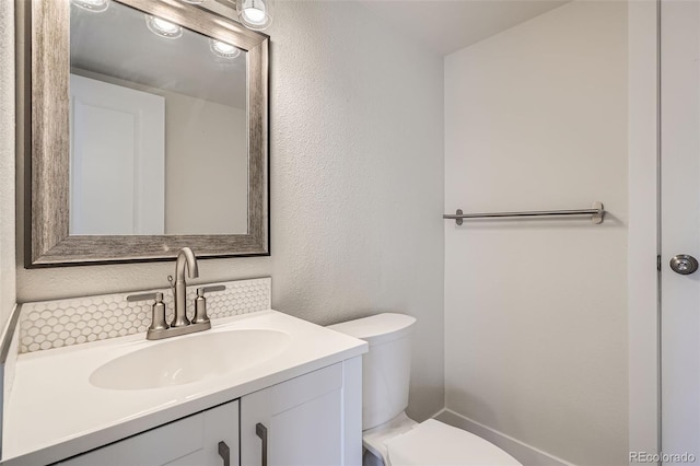 9605 E Kansas Cir Unit 53, Denver, CO 80247 - bathroom featuring toilet, vanity, a textured wall, and tasteful backsplash