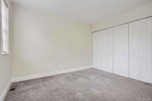 9605 E Kansas Cir Unit 53, Denver, CO 80247 - unfurnished bedroom featuring carpet flooring, multiple windows, and baseboards