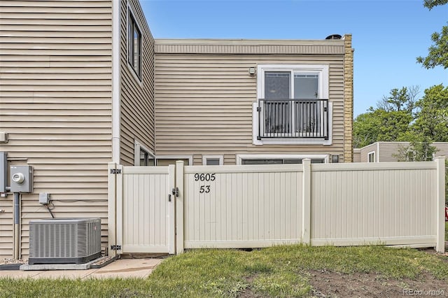 9605 E Kansas Cir Unit 53, Denver, CO 80247 - view of property exterior with central AC and a gate