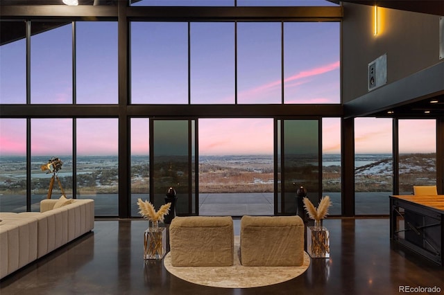 living room featuring a water view, a towering ceiling, and floor to ceiling windows