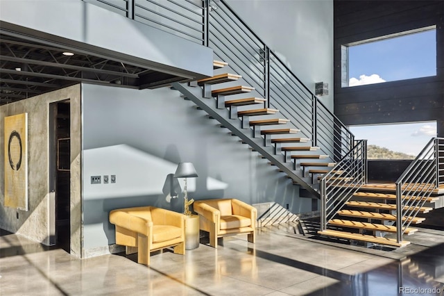 stairs featuring a healthy amount of sunlight and a towering ceiling