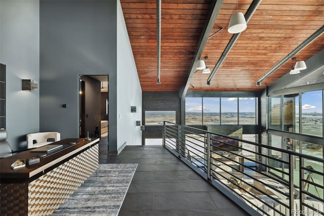 hallway with a towering ceiling and wood ceiling