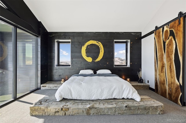 carpeted bedroom featuring vaulted ceiling, access to outside, a barn door, and multiple windows