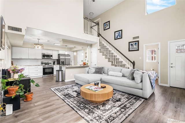 21535 E 39th Ave, Denver, CO 80249 - living area with wood finished floors, a towering ceiling, stairs, and a tray ceiling