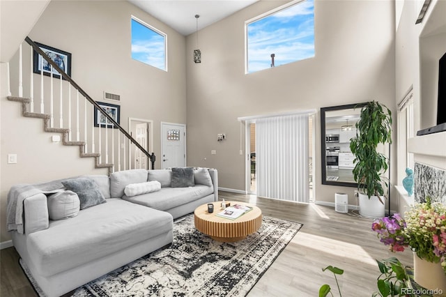 21535 E 39th Ave, Denver, CO 80249 - living area featuring wood finished floors, stairs, and a towering ceiling