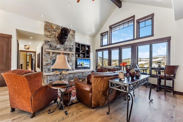 living room with high vaulted ceiling, beamed ceiling, a stone fireplace, and hardwood / wood-style floors