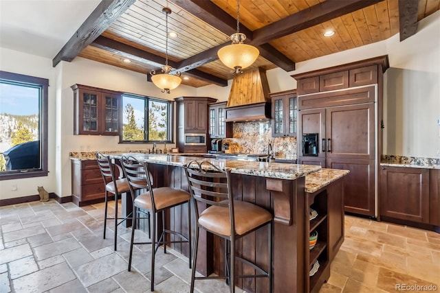 kitchen with wood ceiling, stone tile flooring, and baseboards