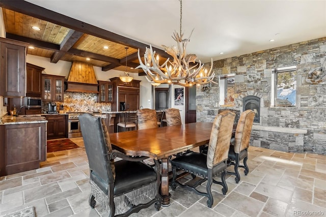 dining area with a notable chandelier, stone tile floors, recessed lighting, wood ceiling, and beamed ceiling