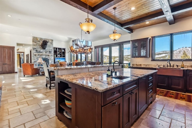 kitchen with stone tile flooring, a fireplace, open shelves, a sink, and recessed lighting