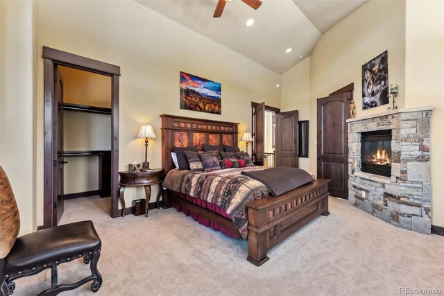 bedroom featuring recessed lighting, light colored carpet, a ceiling fan, a stone fireplace, and high vaulted ceiling