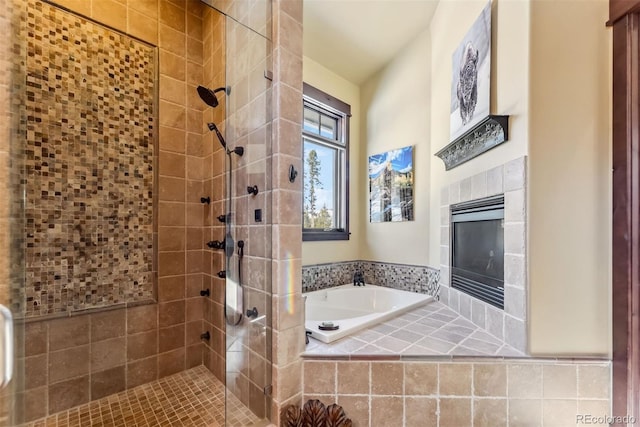 bathroom with a garden tub, a tiled fireplace, and a shower stall