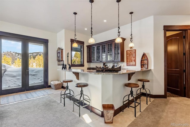 bar with light colored carpet, french doors, decorative light fixtures, and baseboards