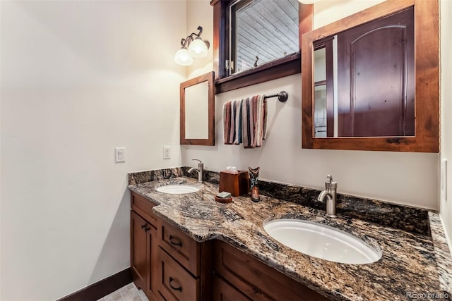 bathroom with double vanity, baseboards, and a sink