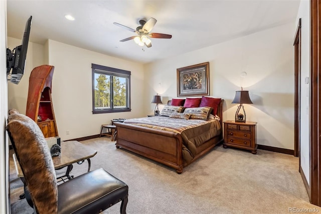 bedroom with a ceiling fan, light carpet, and baseboards